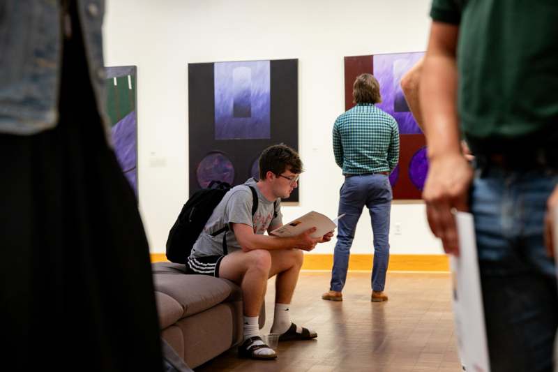 a man sitting on a couch reading a book