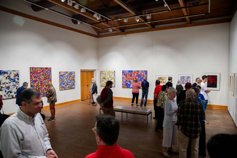 a group of people in a room with art on the wall