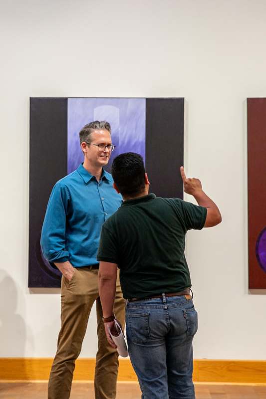 a man pointing at a painting