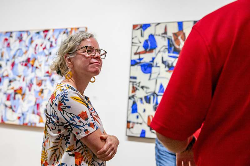 a woman in glasses looking at a man in a red shirt