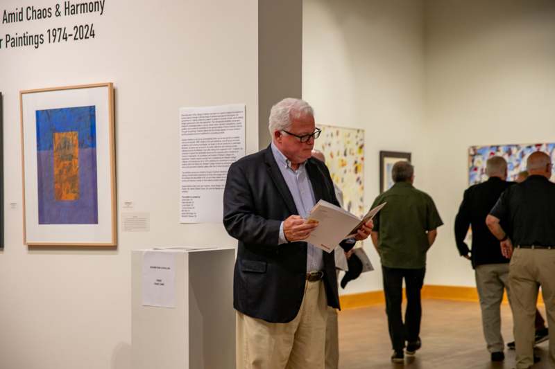 a man in a suit reading a book in a museum