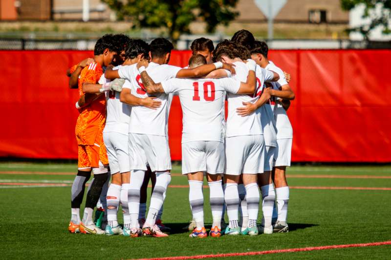 a group of football players huddle on a field