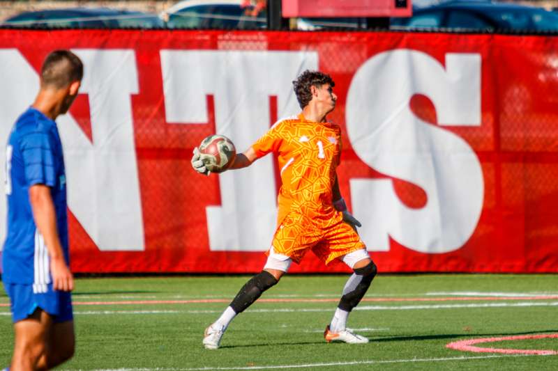 a man in an orange uniform holding a football ball