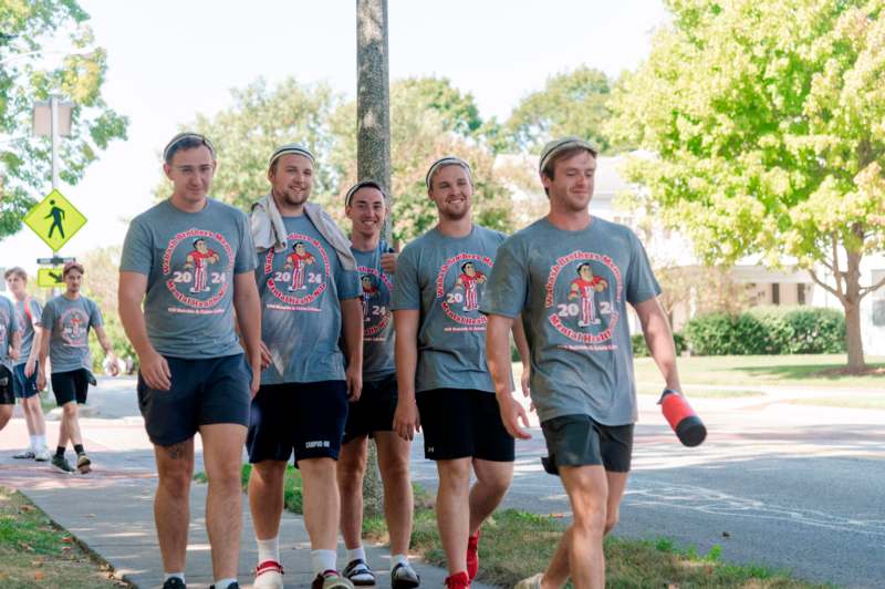 a group of men walking on a sidewalk