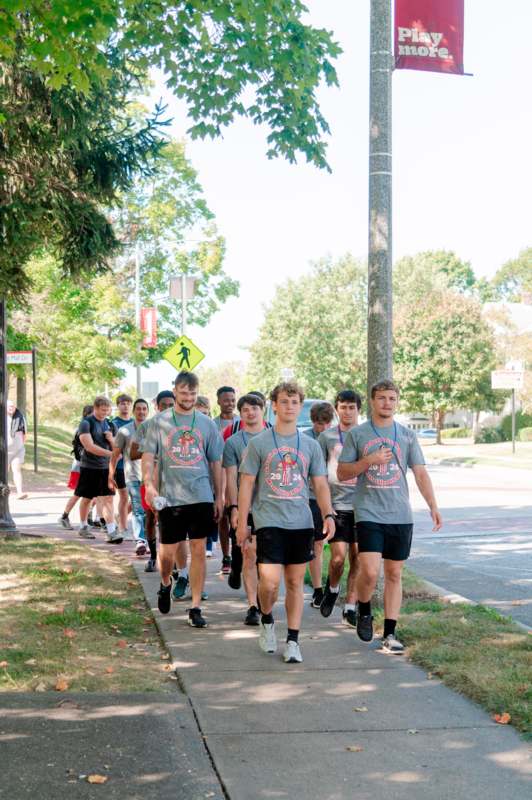 a group of people walking on a sidewalk