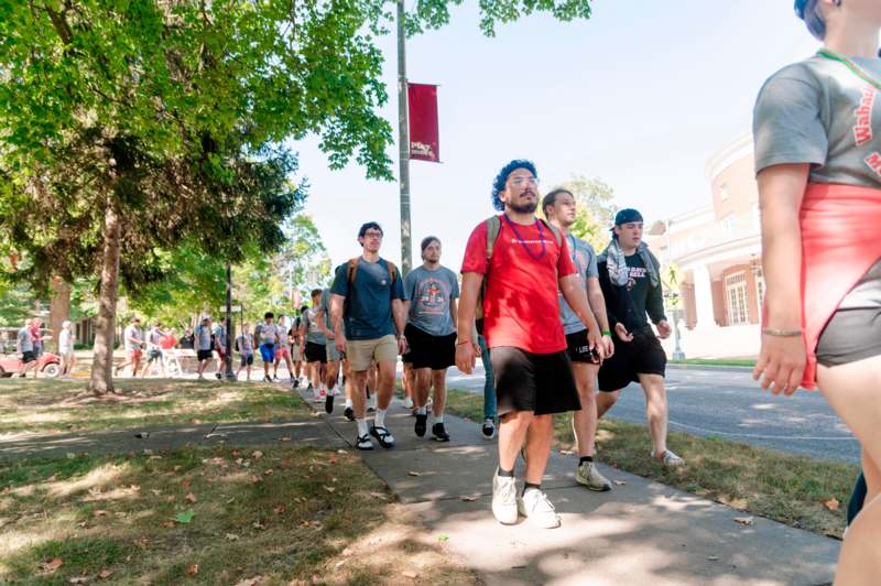 a group of people walking on a sidewalk