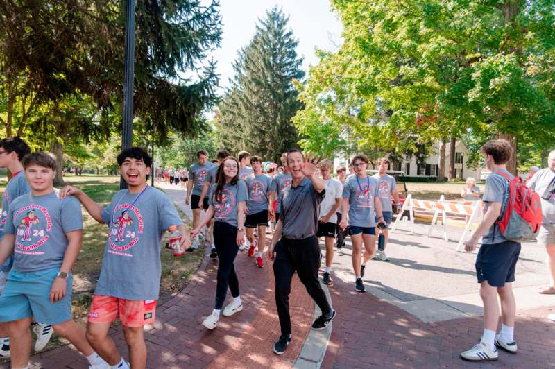 a group of people walking on a sidewalk