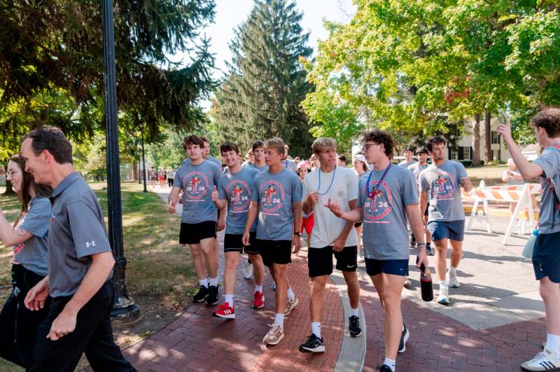 a group of people walking on a sidewalk