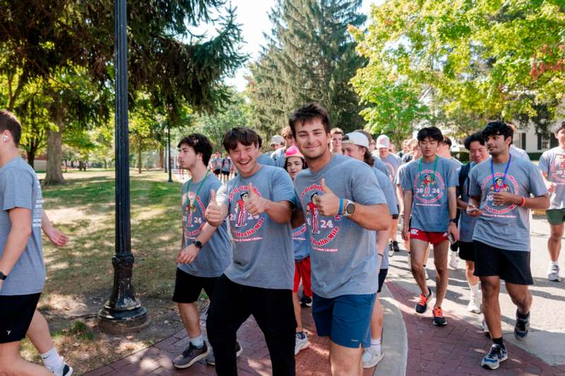 a group of people walking on a sidewalk