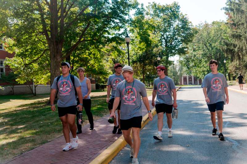 a group of people walking on a sidewalk