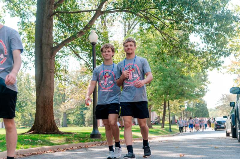 two men walking on a sidewalk