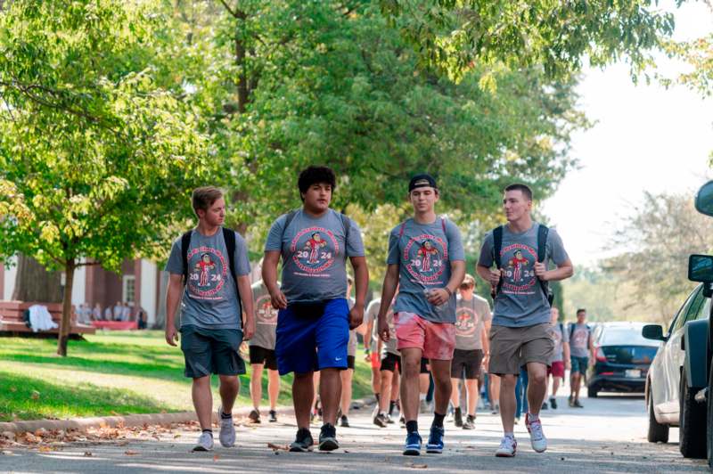 a group of people walking on a sidewalk