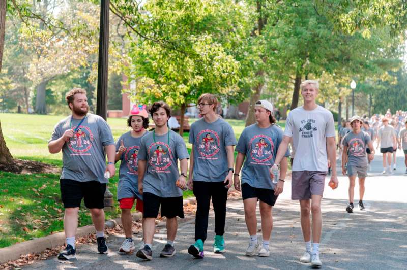 a group of people walking on a sidewalk