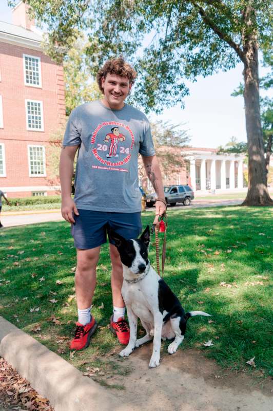 a man standing next to a dog