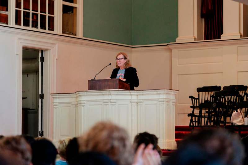 a woman standing at a podium with a microphone