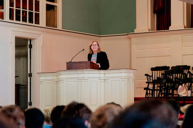 a woman standing at a podium with a microphone