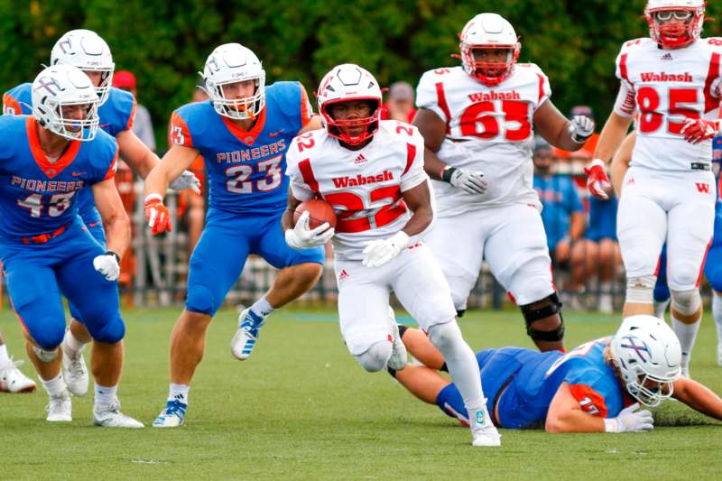 a group of football players running on a field