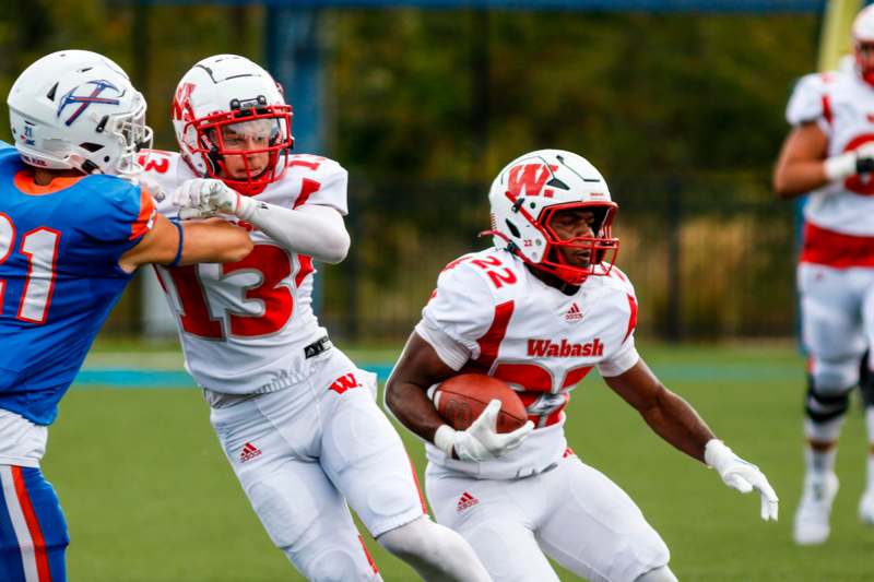 two football players running with a football