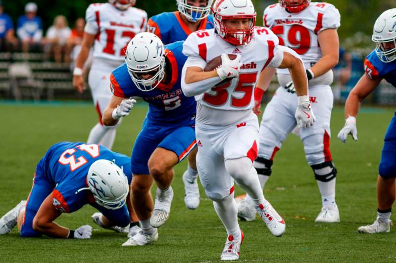 a group of football players running on a field