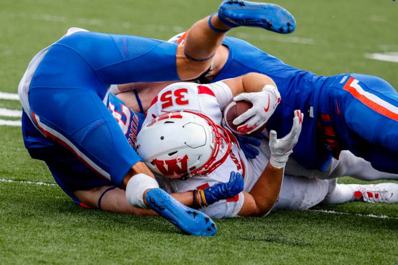 a football player in a blue uniform with a football in the middle