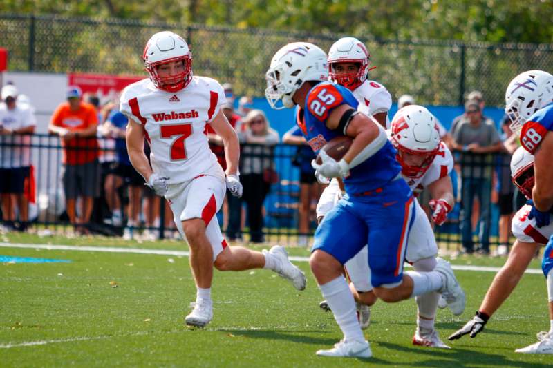 a group of football players running on a field