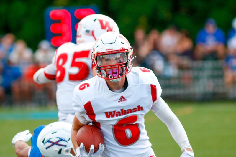 a football player in a helmet holding a football