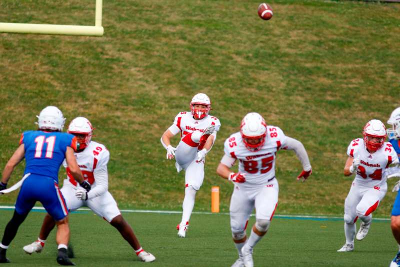 a football player in a white uniform running with a football