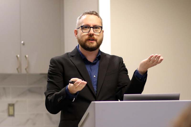 a man standing at a podium with his hands out