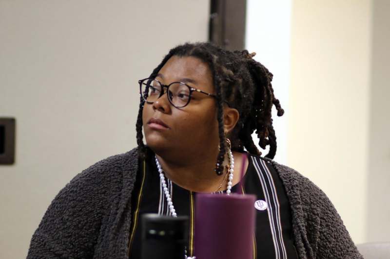 a woman wearing glasses and a grey cardigan