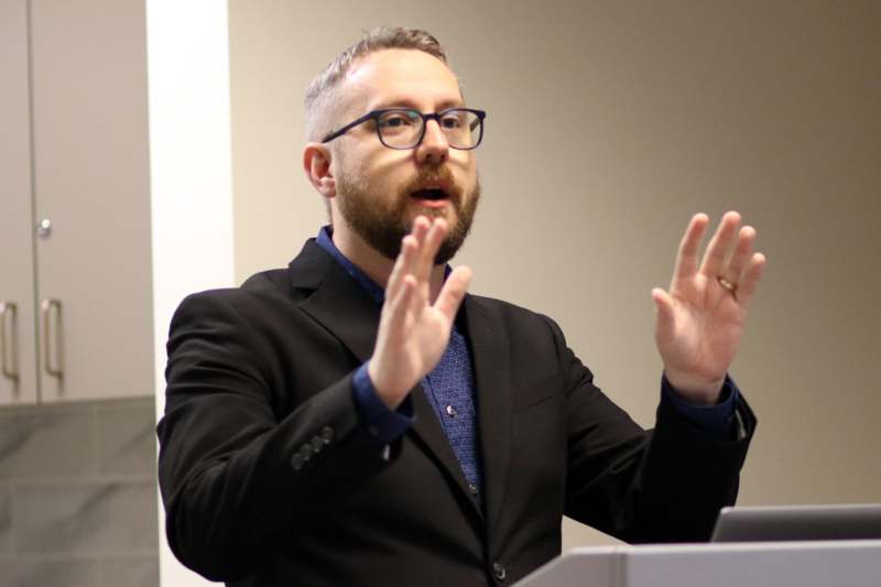 a man in a suit speaking at a podium