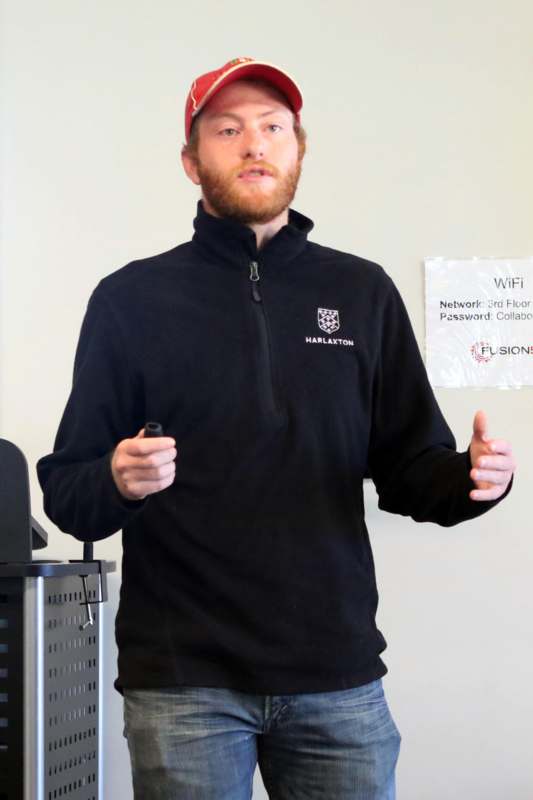 a man with red hair wearing a black jacket and holding a microphone