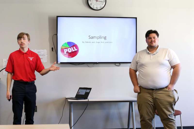 a group of men standing in front of a screen