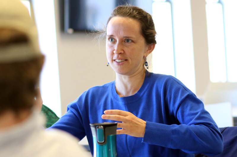 a woman in a blue shirt talking to a man