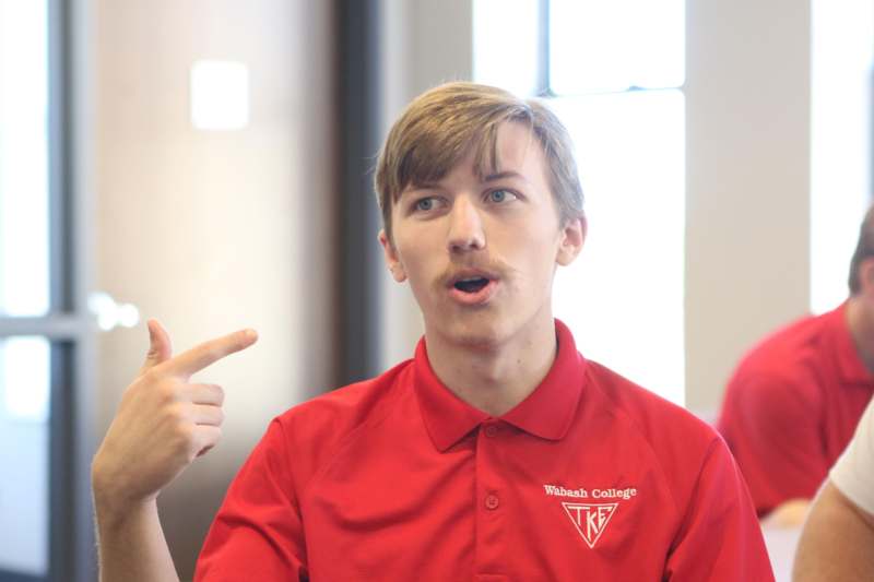 a man in a red shirt pointing his finger