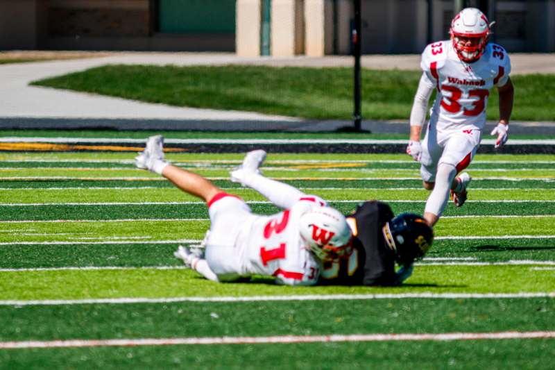 a football player falling off of a football player on a field