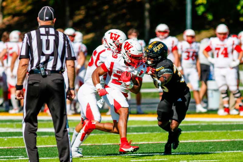 a football players running with a football player in the back