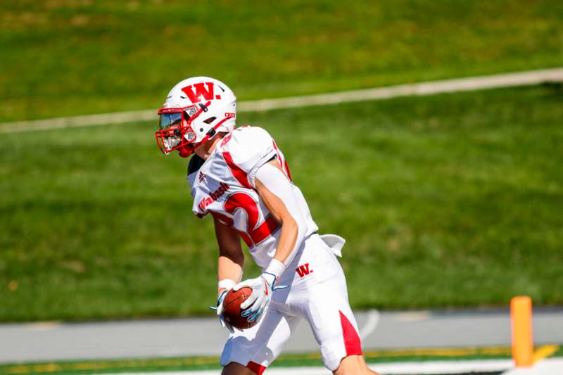 a football player in a uniform holding a football