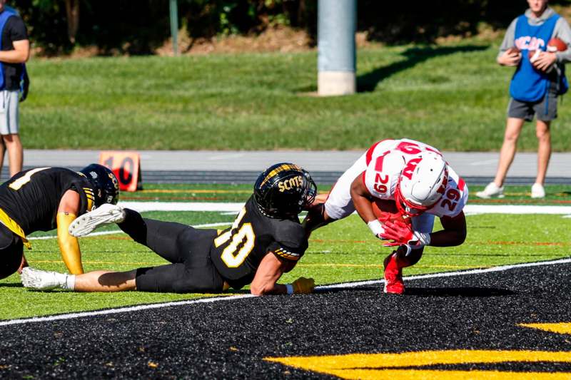 a football player falling off of a football player