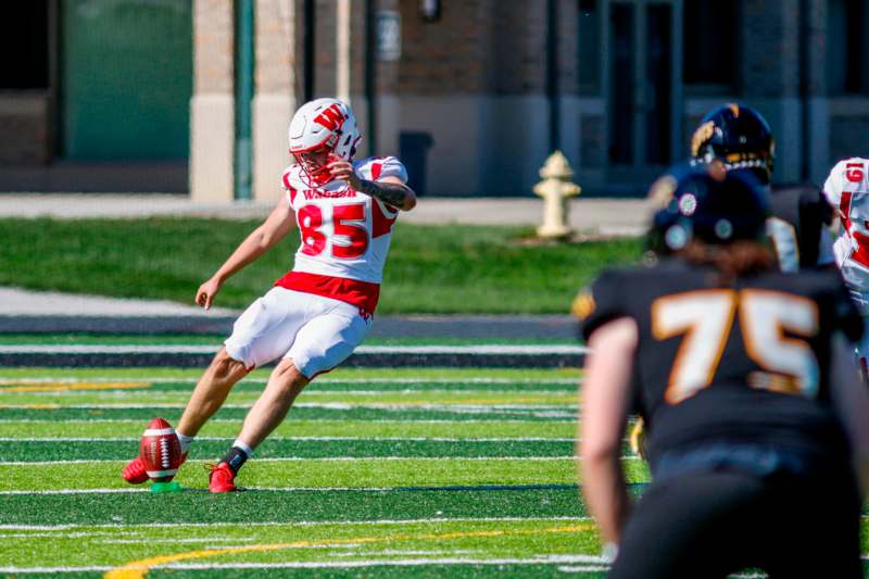 a football player in a uniform running with the ball