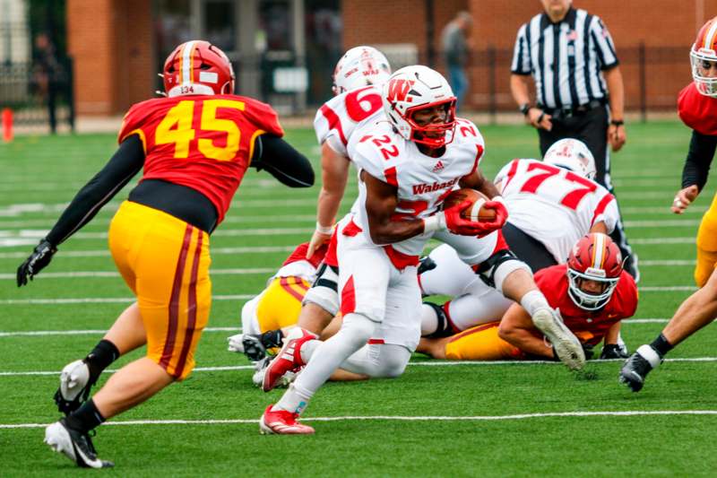 a football player in a red uniform running with the ball