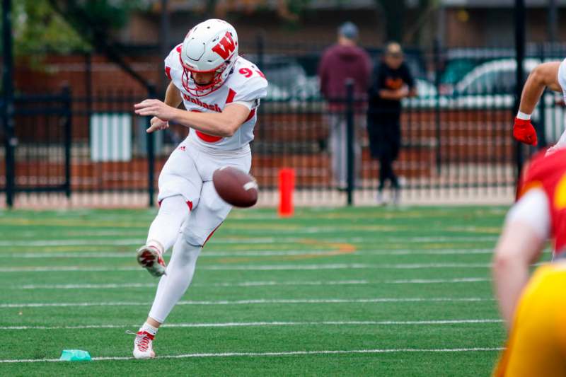 a football player in a uniform kicking a football