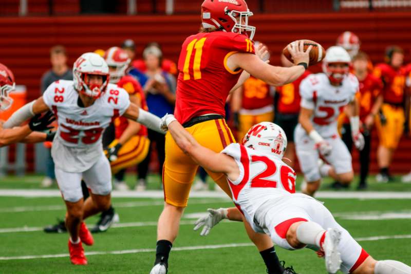 a football player in a red uniform with a football in the back