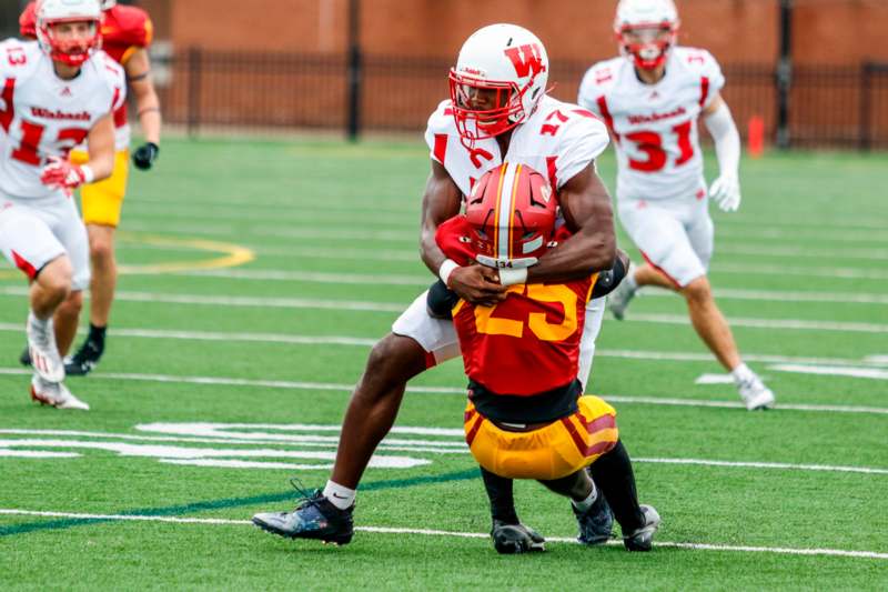 a football player holding another football player