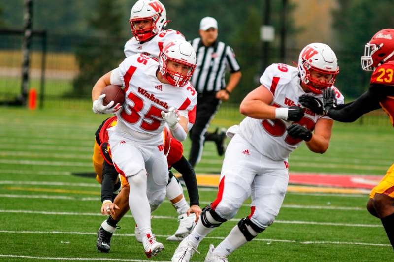 a group of football players running on a field