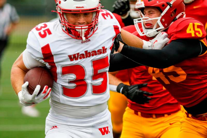 a football player in a uniform running with a football