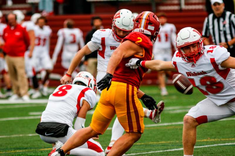 a football player in a red uniform running with a football