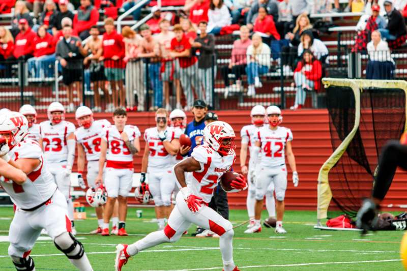 a football player running with a football in his hand