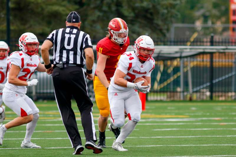 a football player running with a football in the back