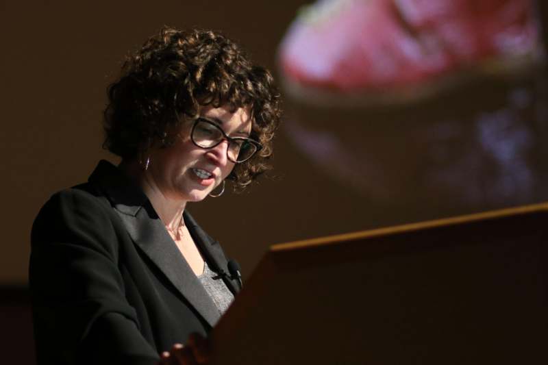 a woman in a suit looking at a screen