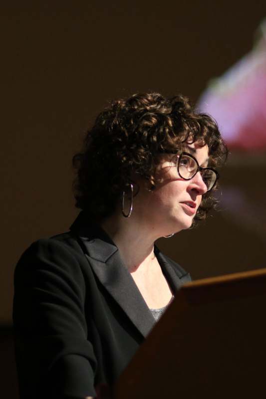 a woman with curly hair wearing glasses